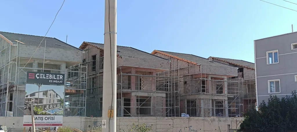 İnşaat halindeki bitişik villalarda iskele kurulu, kiremit kaplı yeni çatılar