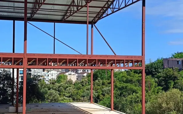 Kırmızı boyalı çelik makaslar üzerine oturtulmuş sac çatı örtüsü