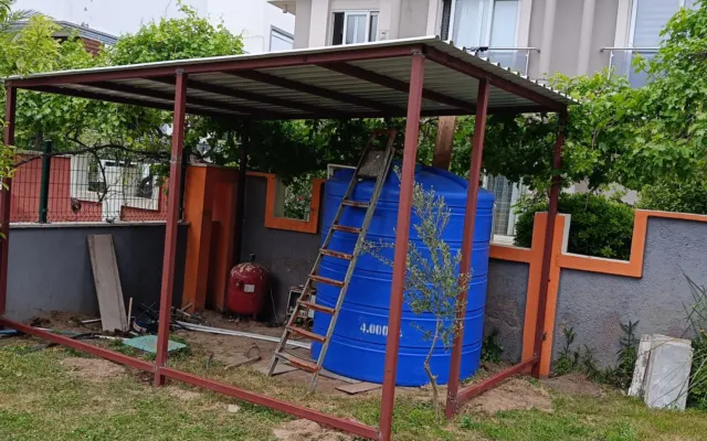 Bahçede çelik profilli sundurma iskeleti ve sac örtü montajı