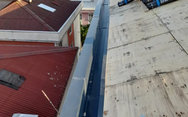 İki bina arasında gri gizli dere sacı ve membran ruloları
