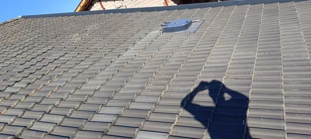 Gri beton kiremit kaplı eğimli çatıda havalandırma elemanı detayı